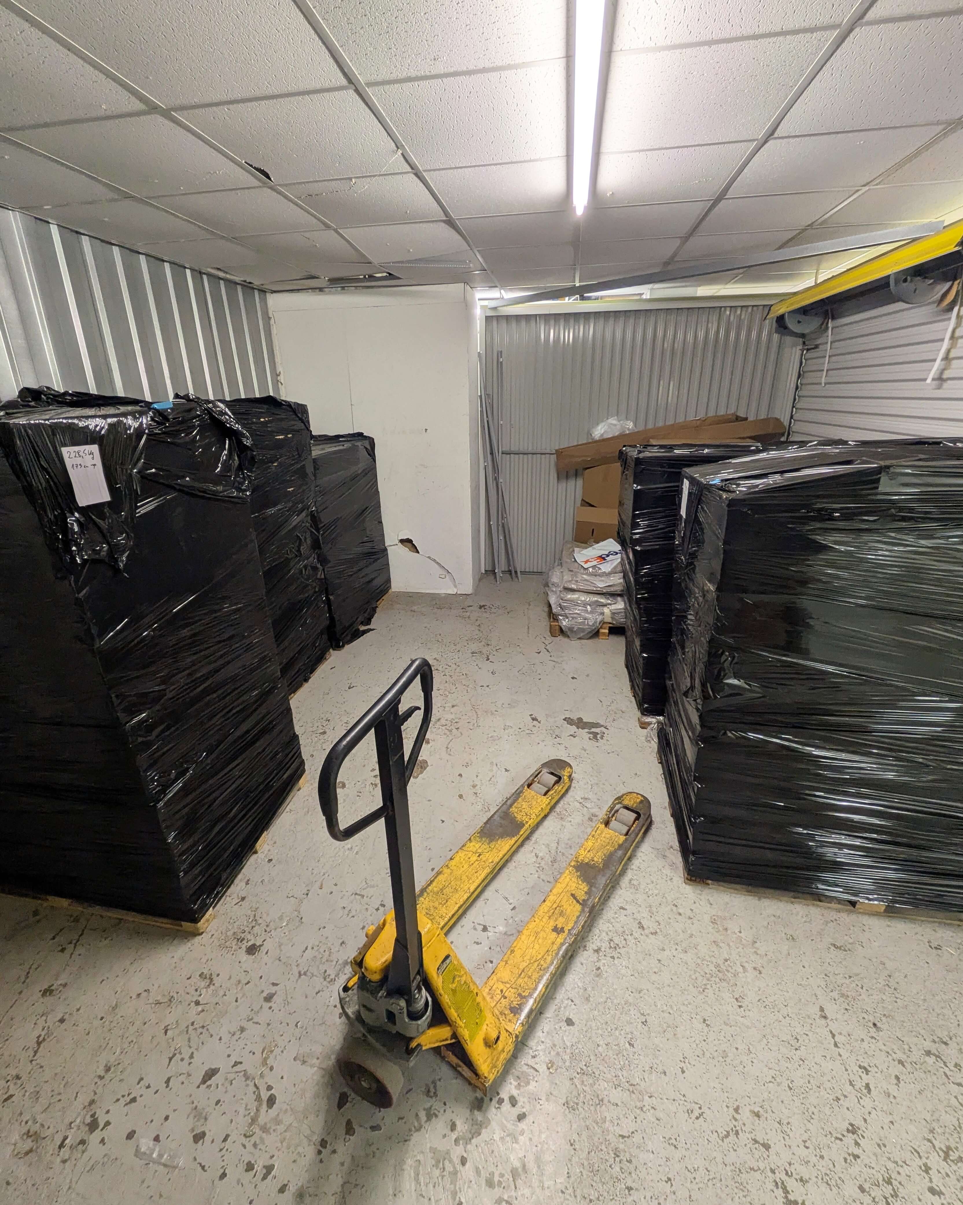 Wrapped furniture and storage pallets secured inside an indoor storage unit in Birmingham