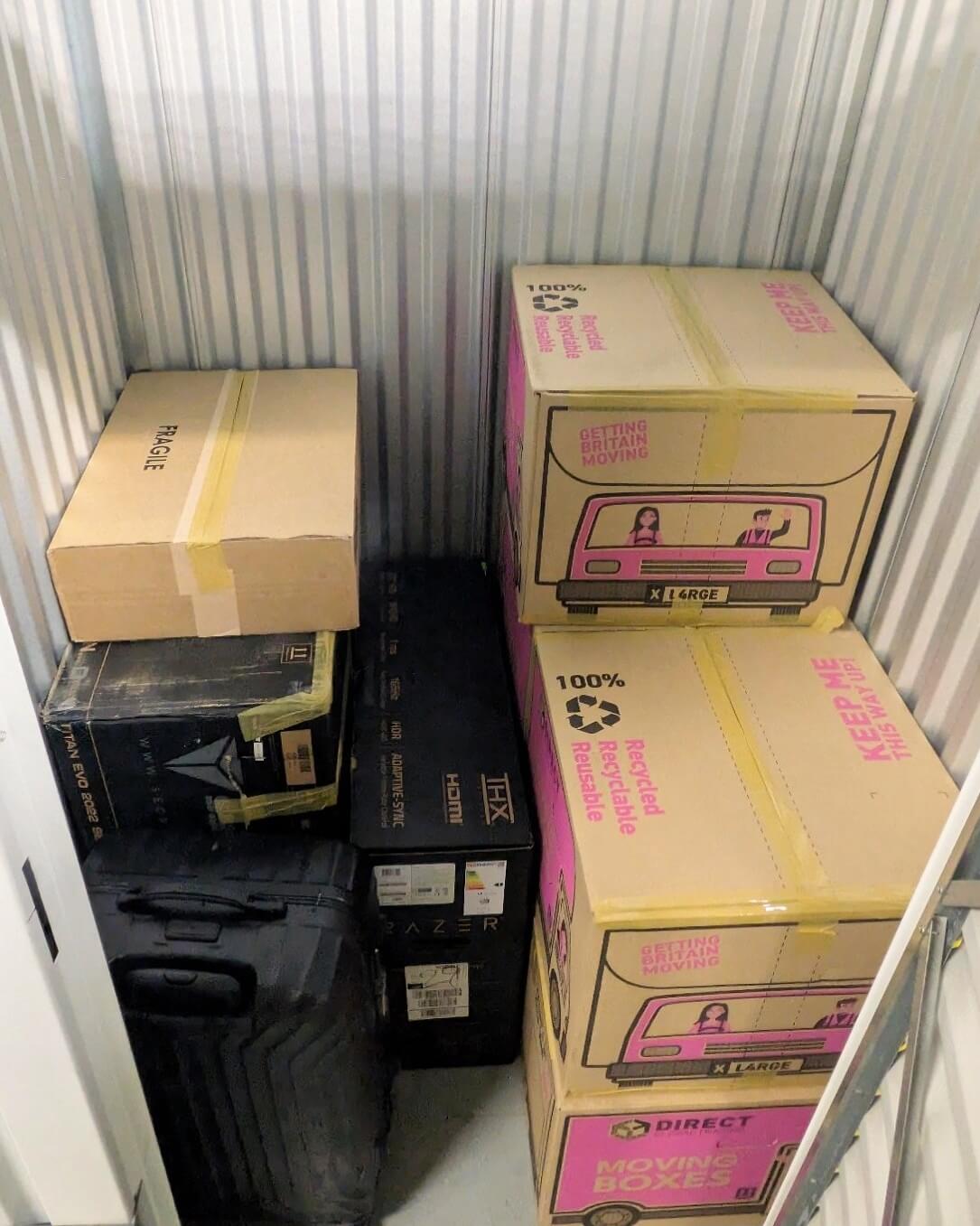 Small storage unit in Birmingham with moving boxes, luggage and household belongings