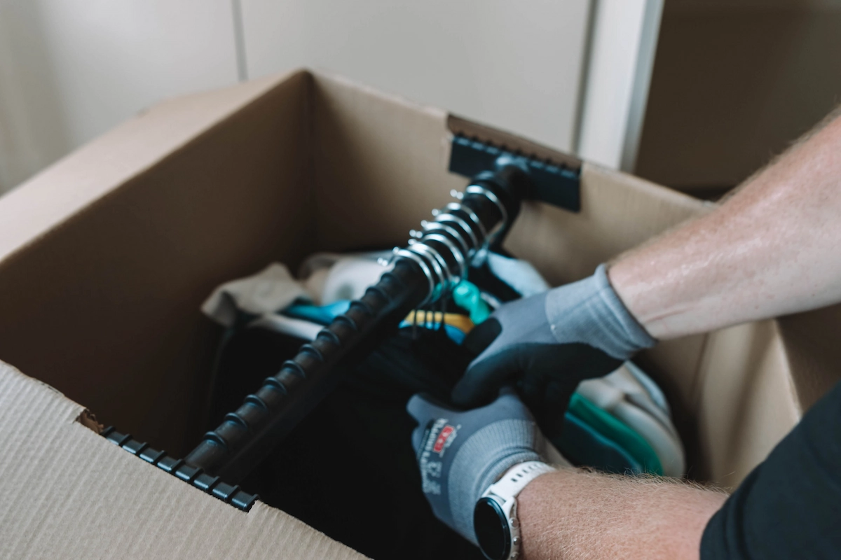 ShiftMate Removals team member packing clothes into a wardrobe box