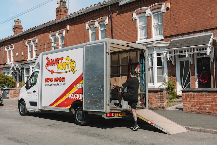 A ShiftMate mover loading a branded van with the belongings of a customer