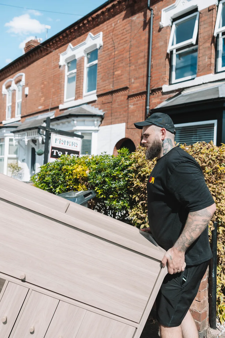 ShiftMate mover carefully carrying a wooden cabinet from a home