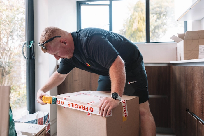 ShiftMate mover sealing a packed box during a house removal