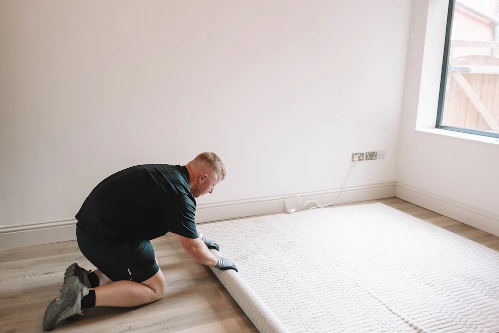 ShiftMate mover carefully rolling a rug inside a customer’s home