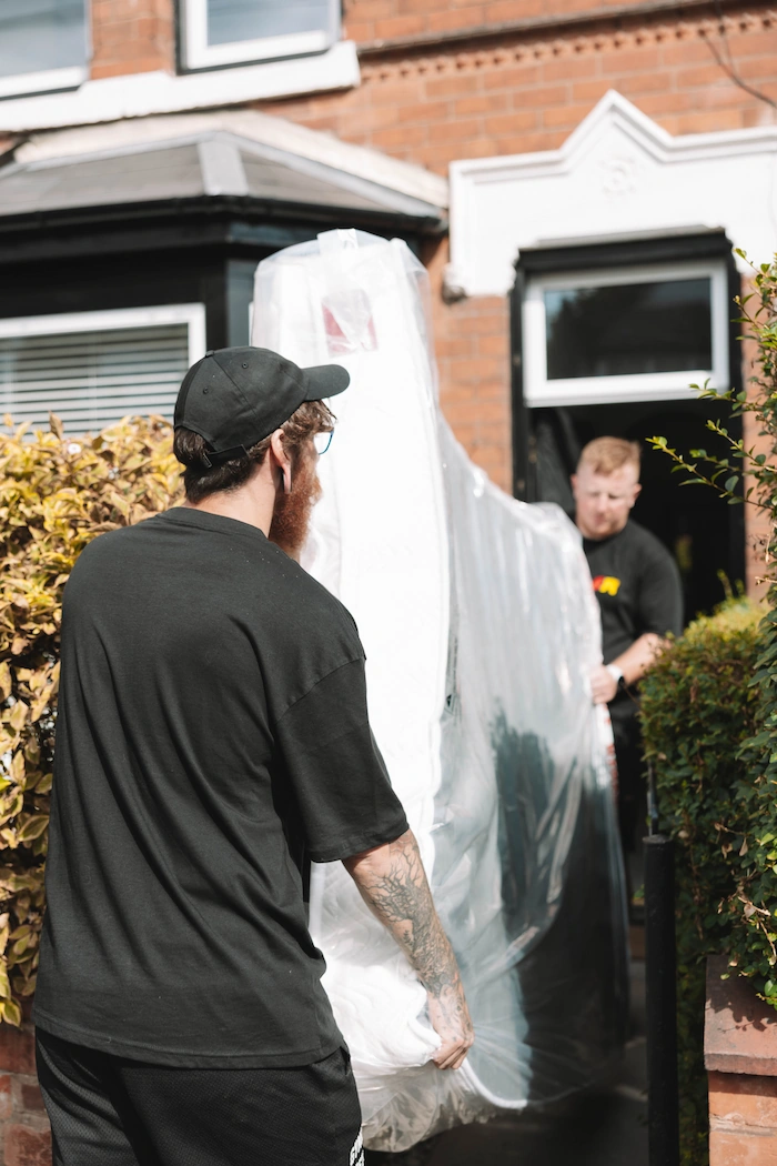 ShiftMate movers carrying protected furniture from a customer’s home