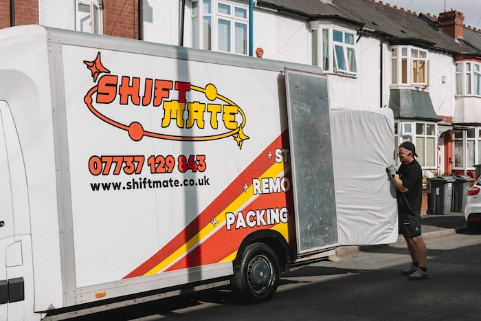 A ShiftMate mover loading a mattress into a house removal van